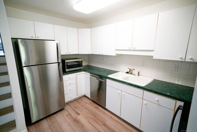 50 E Hill Rd Apt 2H, Canton, CT 06019 - kitchen featuring stainless steel appliances, light wood-style floors, backsplash, dark countertops, and white cabinets