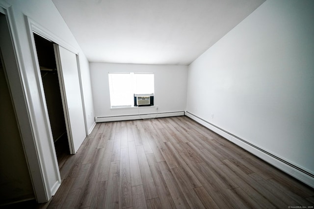 50 E Hill Rd Apt 2H, Canton, CT 06019 - unfurnished bedroom featuring a baseboard radiator, wood finished floors, a closet, and cooling unit