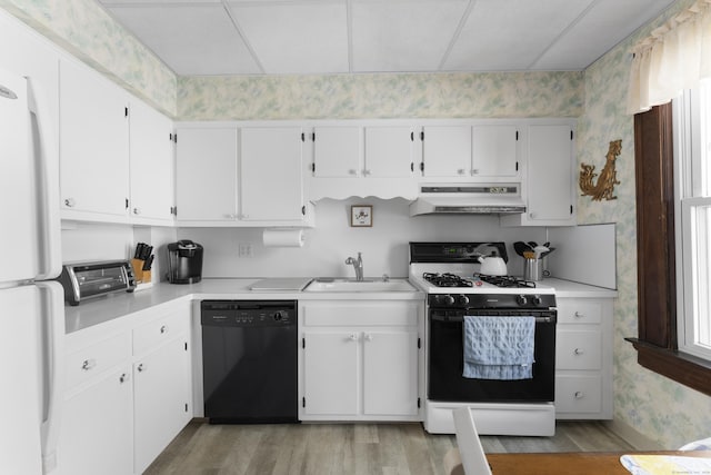 1176 Ocean Ave, New London, CT 06320 - kitchen featuring dishwasher, range with gas stovetop, under cabinet range hood, wallpapered walls, and light wood-type flooring