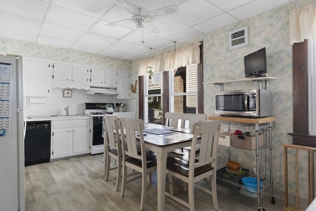 1176 Ocean Ave, New London, CT 06320 - dining space featuring wallpapered walls, a drop ceiling, ceiling fan, and light wood-style flooring