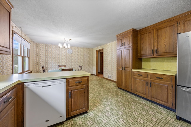 229 Flanders Rd, Southington, CT 06489 - kitchen featuring white dishwasher, wallpapered walls, freestanding refrigerator, a chandelier, and a peninsula