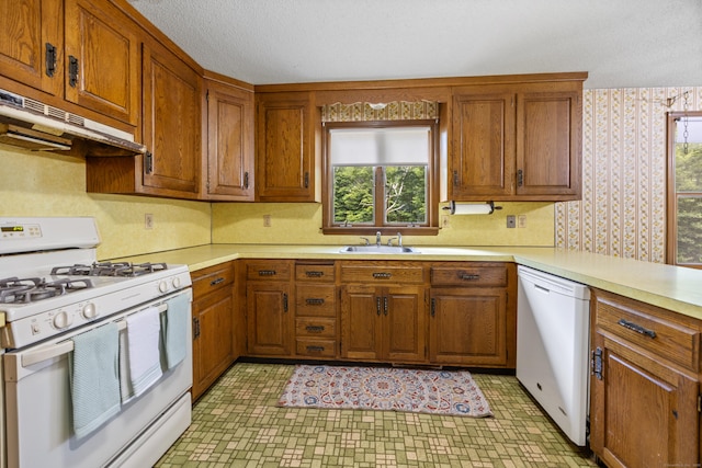 229 Flanders Rd, Southington, CT 06489 - kitchen featuring white appliances, under cabinet range hood, light countertops, brown cabinets, and wallpapered walls