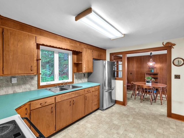 79 E Pattagansett Rd, East Lyme, CT 06357 - kitchen with freestanding refrigerator, backsplash, light countertops, and brown cabinetry