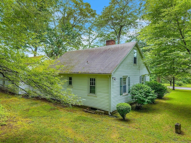 79 E Pattagansett Rd, East Lyme, CT 06357 - view of property exterior featuring a chimney, a yard, and roof with shingles