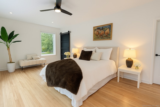 765 Durham Rd, Guilford, CT 06437 - bedroom with a barn door, light wood-style flooring, a ceiling fan, and recessed lighting