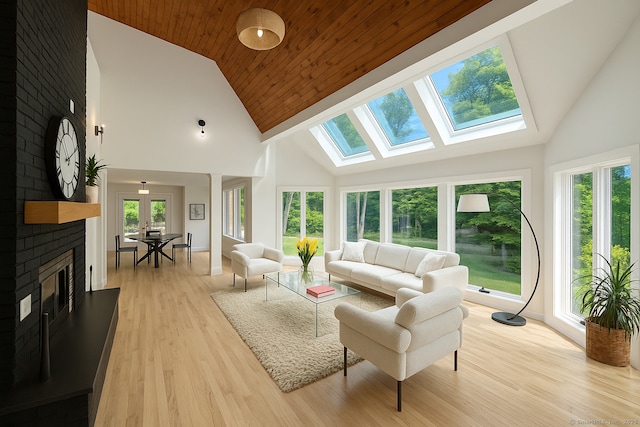 765 Durham Rd, Guilford, CT 06437 - living area featuring plenty of natural light, high vaulted ceiling, a brick fireplace, light wood-style floors, and a skylight
