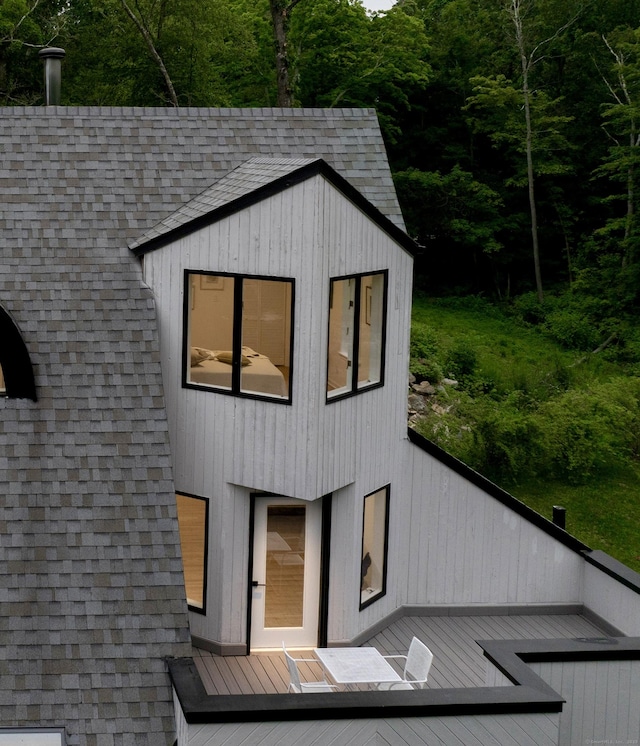 765 Durham Rd, Guilford, CT 06437 - view of front of home featuring a wooden deck, a shingled roof, and a forest view