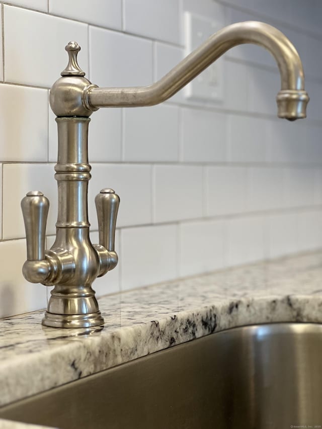 8 Hamre Ln Unit A, Branford, CT 06405 - detailed view of backsplash, light stone countertops, and white cabinetry