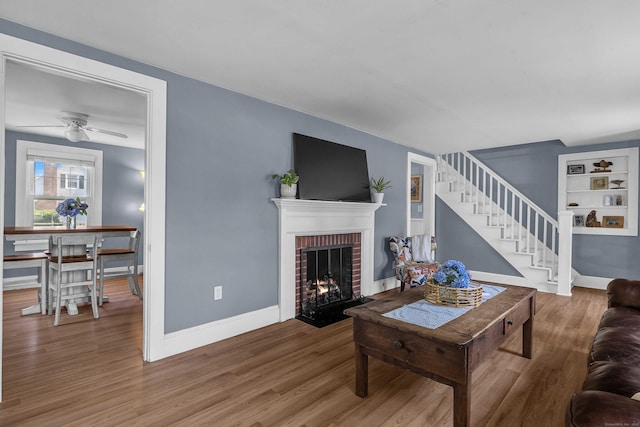 18 Lynde St, Old Saybrook, CT 06475 - living room featuring a brick fireplace, wood finished floors, stairs, and ceiling fan