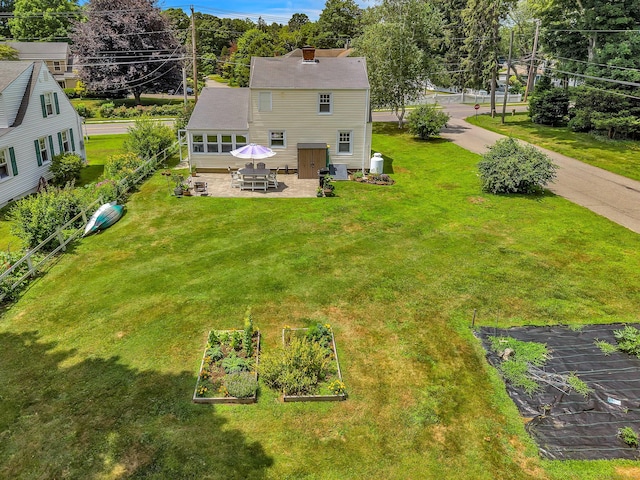 18 Lynde St, Old Saybrook, CT 06475 - rear view of house featuring a garden, a lawn, a patio area, and a chimney