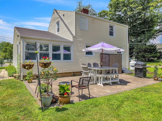 18 Lynde St, Old Saybrook, CT 06475 - rear view of house with a patio area, a lawn, a chimney, and a shingled roof