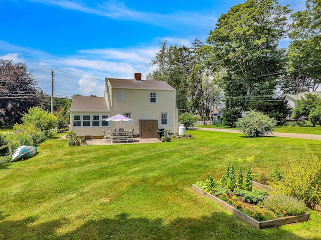 18 Lynde St, Old Saybrook, CT 06475 - rear view of house with a vegetable garden, a yard, a patio area, and a chimney