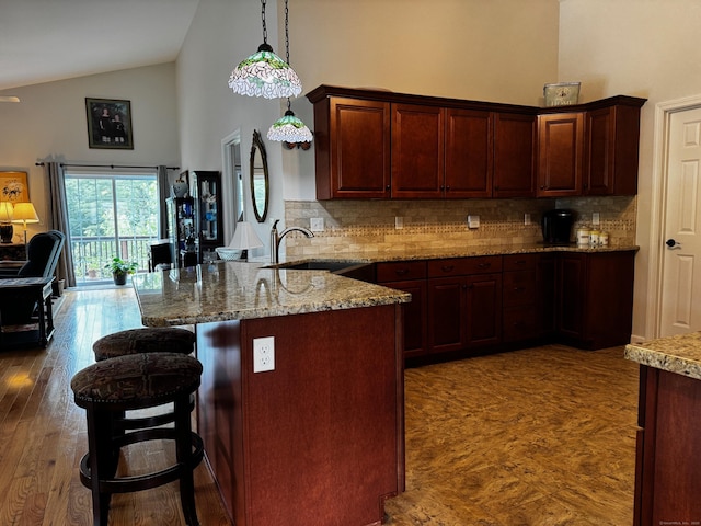 4 Skylark Ln Unit 4, Killingly, CT 06239 - kitchen featuring a kitchen bar, backsplash, high vaulted ceiling, decorative light fixtures, and light stone counters