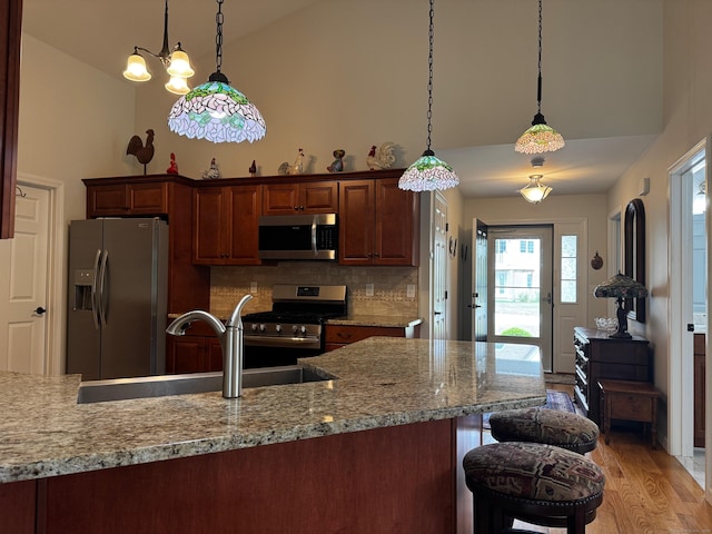 4 Skylark Ln Unit 4, Killingly, CT 06239 - kitchen with appliances with stainless steel finishes, high vaulted ceiling, backsplash, pendant lighting, and a breakfast bar