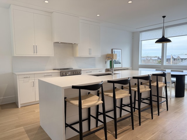 785 Post Rd E Unit 301, Westport, CT 06880 - kitchen with stainless steel stove, light wood-type flooring, light countertops, white cabinets, and recessed lighting