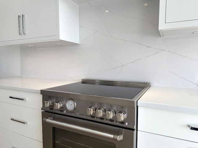 785 Post Rd E Unit 301, Westport, CT 06880 - kitchen view of stainless steel electric range oven, white cabinetry, and light stone counters