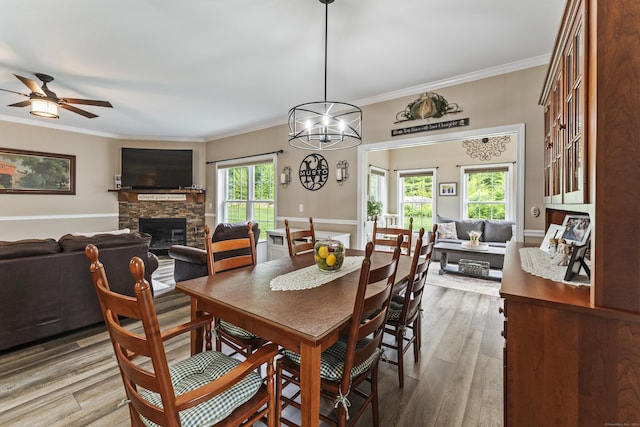 32 Mockingbird Dr Unit 32, Killingly, CT 06239 - dining space featuring a fireplace, crown molding, light wood-type flooring, ceiling fan, and a chandelier