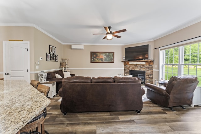 32 Mockingbird Dr Unit 32, Killingly, CT 06239 - living area featuring an AC wall unit, ceiling fan, a fireplace, wood finished floors, and ornamental molding
