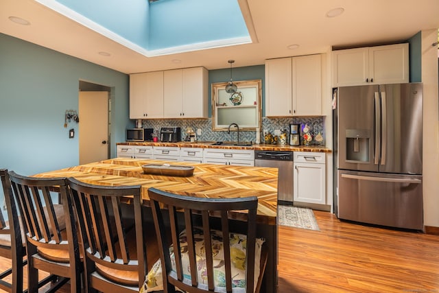 93 Kettletown Woods Rd, Southbury, CT 06488 - kitchen featuring stainless steel appliances, white cabinets, backsplash, light wood-style floors, and decorative light fixtures
