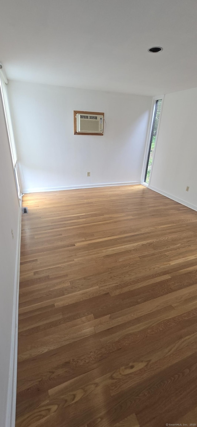 100 Mildred Ave, Waterbury, CT 06708 - empty room with a wall unit AC and wood finished floors