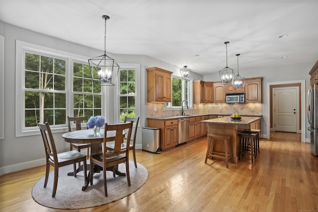 36 Blueberry Ln, Canton, CT 06019 - kitchen with a center island, a chandelier, decorative backsplash, light wood-style floors, and appliances with stainless steel finishes