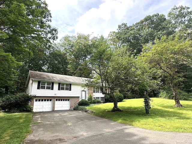 51 Westridge Dr, Avon, CT 06001 - split foyer home featuring an attached garage, asphalt driveway, a front lawn, and brick siding