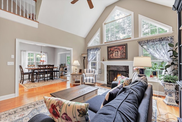24 Windflower Ln, Shelton, CT 06484 - living area with high vaulted ceiling, plenty of natural light, a fireplace, wood finished floors, and ceiling fan