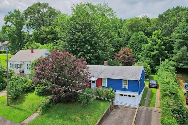 211 Pembroke Ave, Waterbury, CT 06704 - view of front of home featuring roof with shingles, asphalt driveway, an attached garage, a chimney, and a front lawn