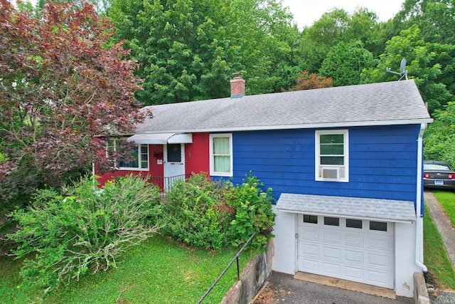 211 Pembroke Ave, Waterbury, CT 06704 - view of front facade with an attached garage, roof with shingles, a chimney, and a front lawn
