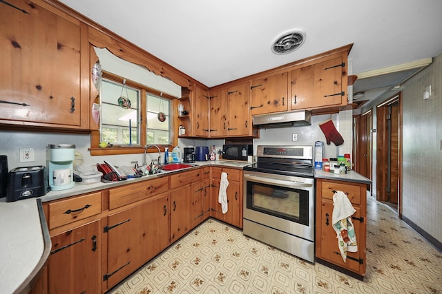 211 Pembroke Ave, Waterbury, CT 06704 - kitchen featuring stainless steel electric stove, under cabinet range hood, black microwave, light flooring, and brown cabinets