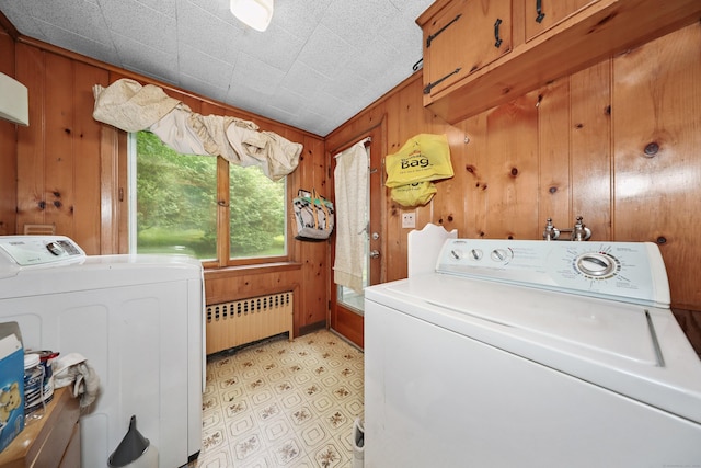 211 Pembroke Ave, Waterbury, CT 06704 - laundry area featuring radiator, cabinet space, wood walls, washing machine and dryer, and light flooring