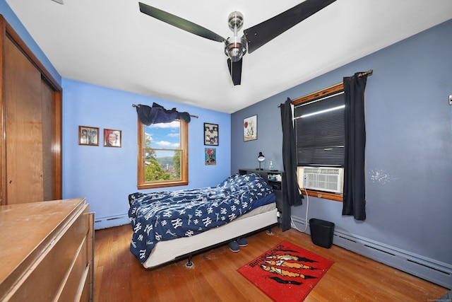 211 Pembroke Ave, Waterbury, CT 06704 - bedroom featuring a baseboard heating unit, wood finished floors, cooling unit, and ceiling fan