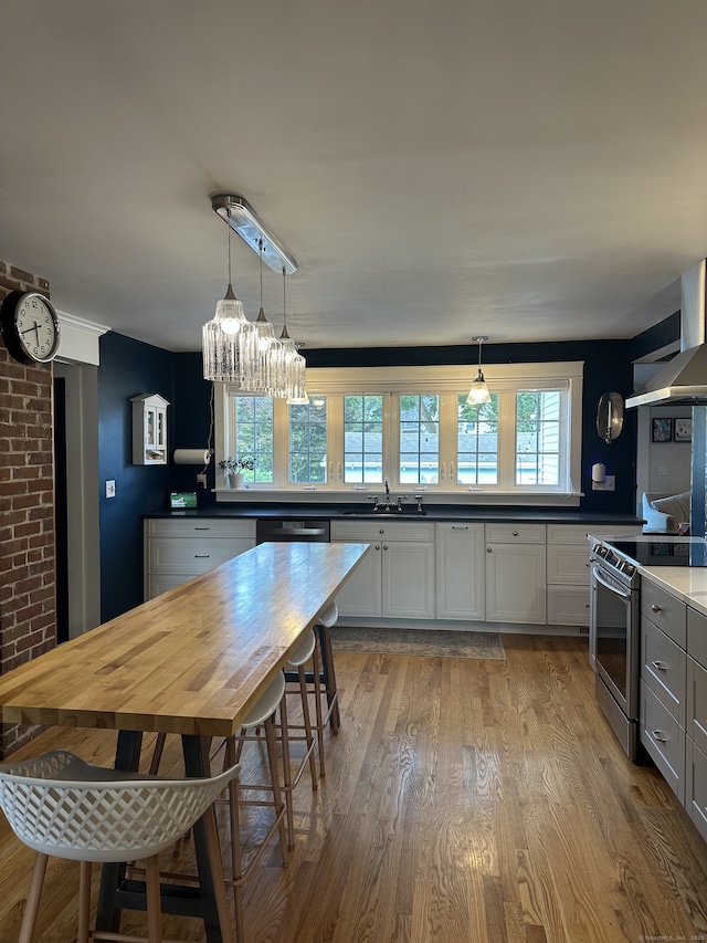 6 Fairview Ave, Wallingford, CT 06492 - kitchen featuring stainless steel range with electric cooktop, exhaust hood, light wood-type flooring, a chandelier, and decorative light fixtures