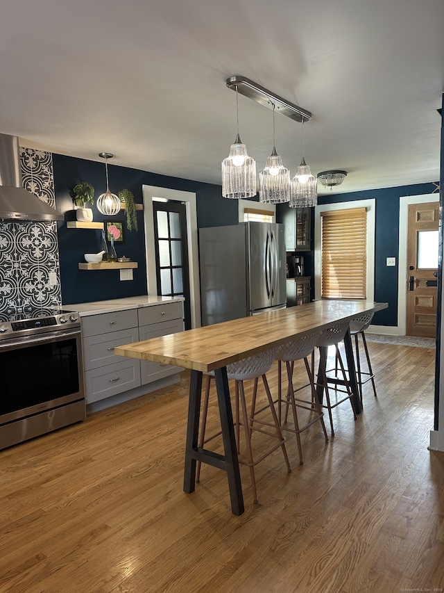 6 Fairview Ave, Wallingford, CT 06492 - kitchen featuring appliances with stainless steel finishes, range hood, wood finished floors, wood counters, and hanging light fixtures