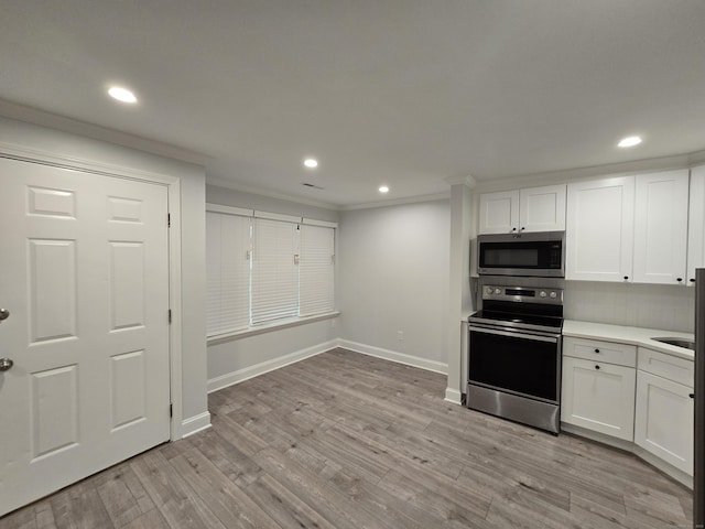 112 Glenwood Ave Unit 112, Bridgeport, CT 06610 - kitchen featuring stainless steel appliances, crown molding, white cabinets, recessed lighting, and light countertops