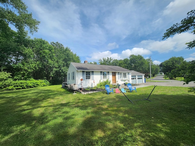 5 Cascio Rd, Ansonia, CT 06401 - back of property with a garage, a chimney, driveway, and a yard