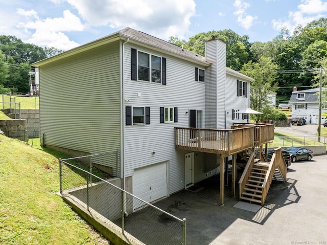 145 Manners Ave, Naugatuck, CT 06770 - rear view of house featuring a garage, a wooden deck, a chimney, and stairs