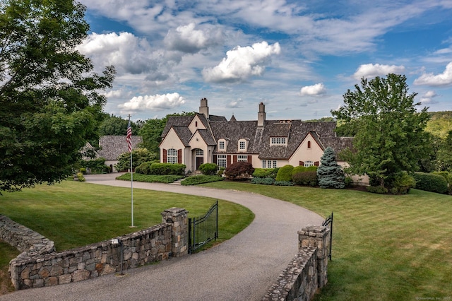 370 Northrop St, Bridgewater, CT 06752 - view of front facade featuring stucco siding, a chimney, curved driveway, a gate, and stone siding