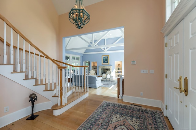 370 Northrop St, Bridgewater, CT 06752 - entrance foyer featuring a high ceiling, wood finished floors, stairway, beam ceiling, and a chandelier