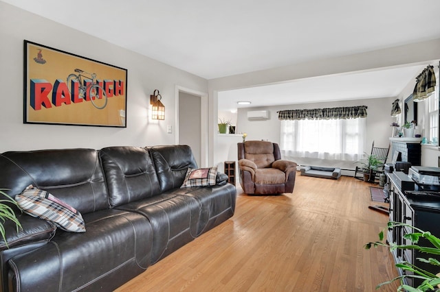 18 Nye St, Vernon, CT 06066 - living area with wood finished floors, an AC wall unit, and a baseboard heating unit