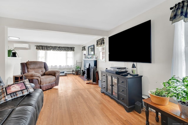 18 Nye St, Vernon, CT 06066 - living area with light wood-type flooring, a wall mounted AC, and a fireplace
