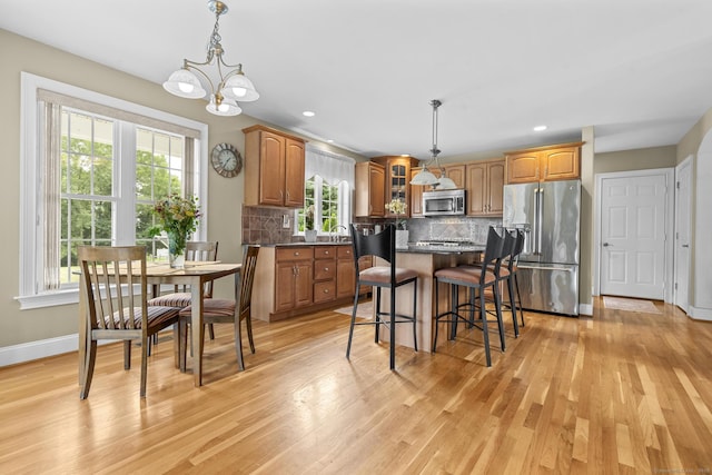 31 Crimson Hts, Portland, CT 06480 - kitchen featuring stainless steel appliances, light wood-type flooring, a chandelier, a kitchen breakfast bar, and decorative backsplash