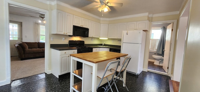 108 School St, Hamden, CT 06518 - kitchen with black microwave, freestanding refrigerator, butcher block countertops, a ceiling fan, and dark flooring