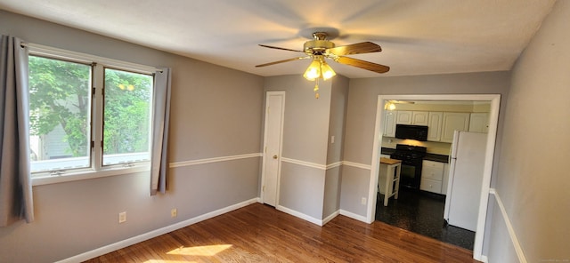 108 School St, Hamden, CT 06518 - unfurnished bedroom featuring dark wood-style flooring, freestanding refrigerator, and ceiling fan