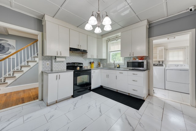 6 Rau Street Ext, Vernon, CT 06066 - kitchen with black electric range, stainless steel microwave, washing machine and clothes dryer, under cabinet range hood, and light marble finish floors