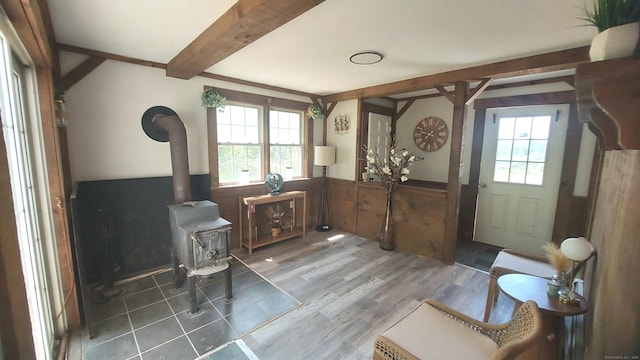 62 Park St, Stafford, CT 06076 - entrance foyer with plenty of natural light, wainscoting, a wood stove, beam ceiling, and wood finished floors
