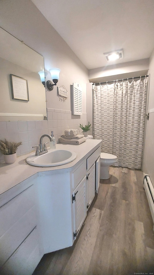 62 Park St, Stafford, CT 06076 - bathroom with wood finished floors, vanity, a shower with curtain, tasteful backsplash, and baseboard heating
