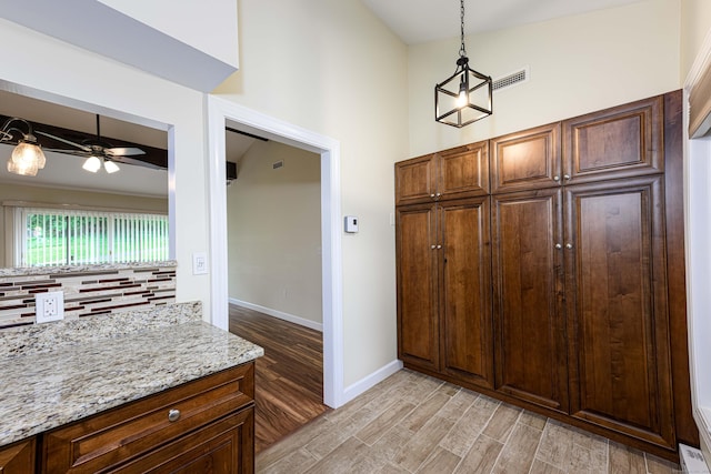 17 Pilgrim Hbr Unit A, Wallingford, CT 06492 - kitchen featuring light wood-style floors, ceiling fan, light stone counters, decorative light fixtures, and a high ceiling