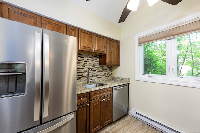 17 Pilgrim Hbr Unit A, Wallingford, CT 06492 - kitchen featuring appliances with stainless steel finishes, baseboard heating, backsplash, light wood-style flooring, and light stone counters