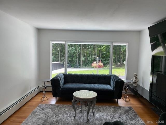 48 Mulberry Rd, Woodbridge, CT 06525 - living area featuring a baseboard heating unit, plenty of natural light, and wood finished floors
